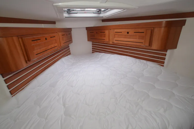 Tahlequah Yacht Photos Pics Cozy cabin interior of 2020 Tartan 365 yacht with wooden cabinets and white bedding.