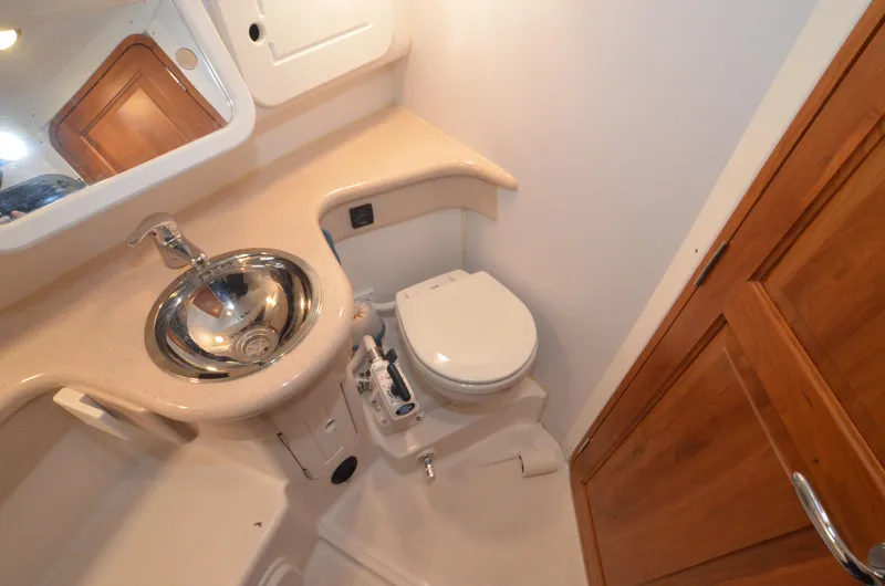 Tahlequah Yacht Photos Pics Compact bathroom in 2020 Tartan 365 yacht with stainless steel sink and wooden cabinetry.