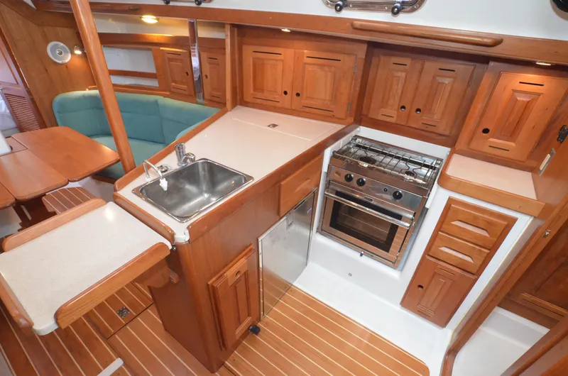 Tahlequah Yacht Photos Pics Luxurious Tartan 365 yacht interior with wooden cabinetry, compact kitchen, and cozy seating area, 2020 model.