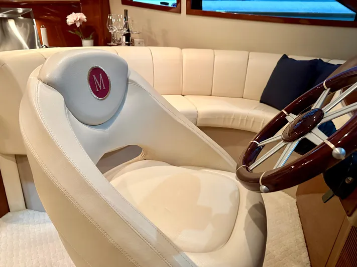Tenacity Yacht Photos Pics Luxurious interior of a 2005 Marquis 65 yacht with plush seating and elegant steering wheel.