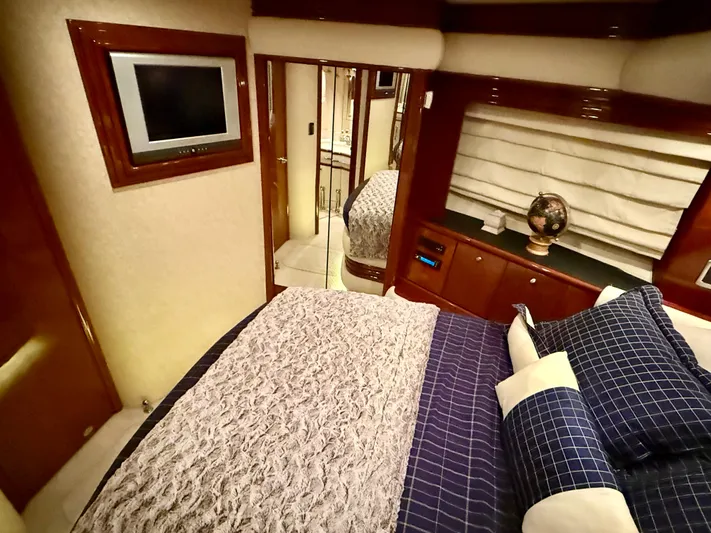 Tenacity Yacht Photos Pics Luxurious bedroom interior of 2005 Marquis 65 yacht with elegant bedding and modern decor.