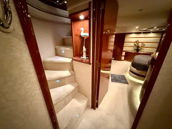Tenacity Yacht Photos Pics Luxurious interior of a 2005 Marquis 65 yacht, featuring elegant stairs and cozy bedroom.