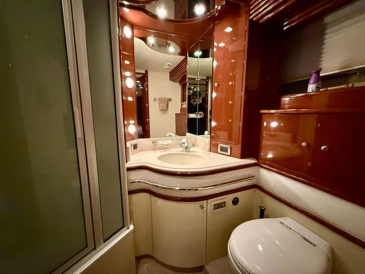 Tenacity Yacht Photos Pics Luxurious bathroom in a 2005 Marquis 65 yacht with elegant wood finishes.