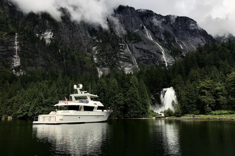 Front Row Yacht Photos Pics Luxury 2006 NorthCoast PILOTHOUSE yacht near scenic waterfall and forested mountains.