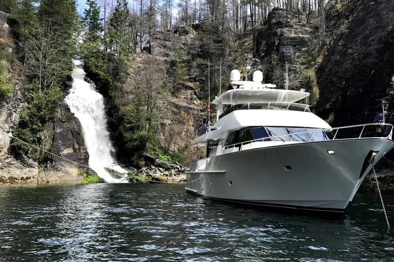 Front Row Yacht Photos Pics Luxury 2006 NorthCoast PILOTHOUSE yacht near scenic waterfall and rocky cliffs.
