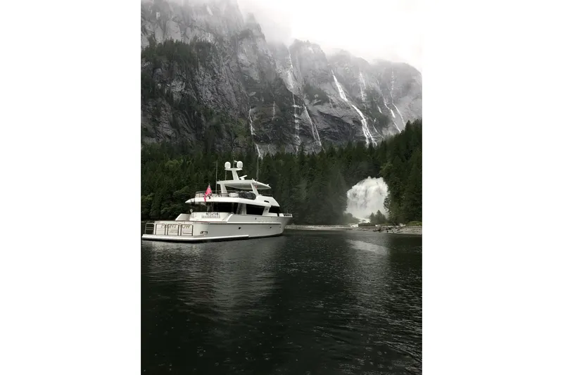 Front Row Yacht Photos Pics Luxury 2006 NorthCoast PILOTHOUSE yacht near scenic waterfall and forested cliffs.