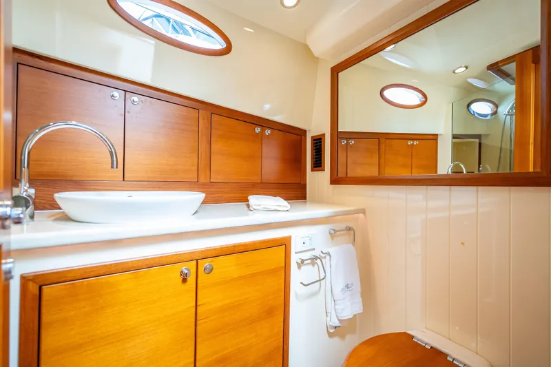 Stella Yacht Photos Pics Luxurious 2018 Palm Beach Motor Yachts PB50 bathroom with wooden cabinetry and modern fixtures.