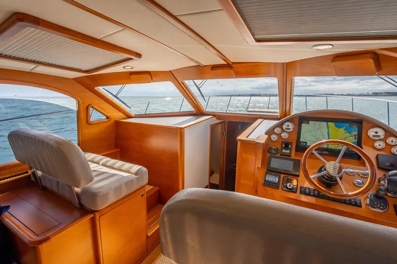 Stella Yacht Photos Pics 2018 Palm Beach Motor Yachts PB50 helm with navigation system, luxurious wood finish, and ocean view.