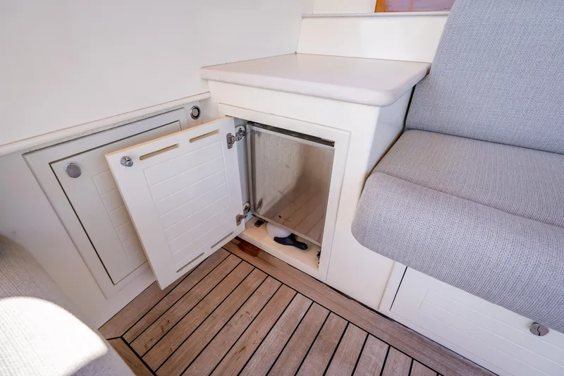 Stella Yacht Photos Pics 2018 Palm Beach Motor Yachts PB50 interior with open storage compartment and cushioned seating.