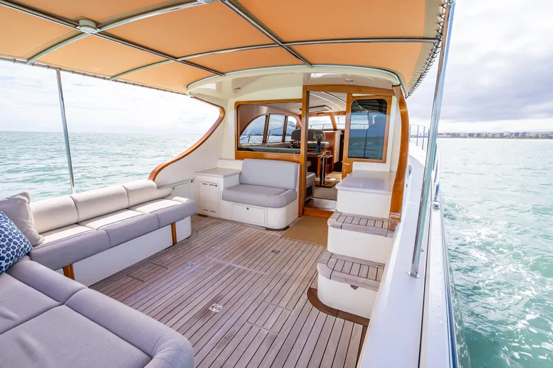 Stella Yacht Photos Pics 2018 Palm Beach Motor Yachts PB50, luxurious deck with seating, cruising on open water.