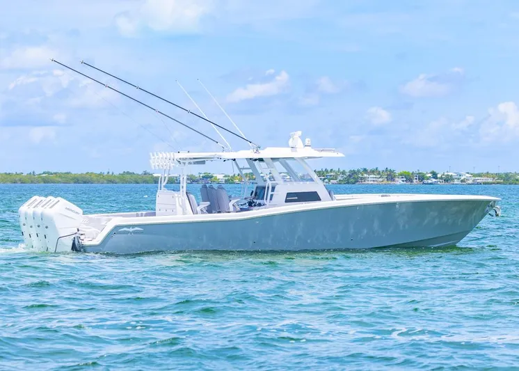  Yacht Photos Pics 2025 Invincible 43 Open Fisherman boat on calm blue water, clear sky background.