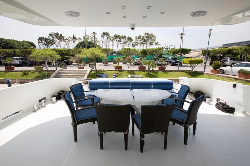 Tamteen Yacht Photos Pics Outdoor seating area on 1998 Trident 127 yacht with blue chairs and table.