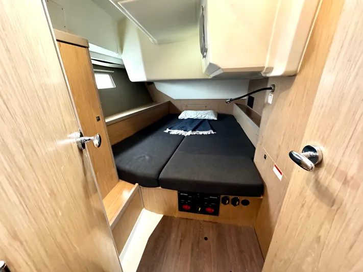  Yacht Photos Pics 2018 Beneteau Oceanis 45 cabin interior with wooden finish and cozy bedding.