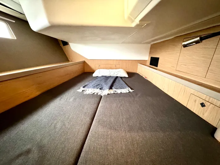  Yacht Photos Pics 2018 Beneteau Oceanis 45 cabin interior with cozy bed and wooden accents.