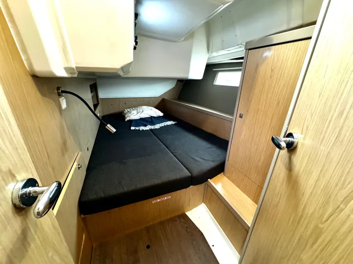  Yacht Photos Pics Cabin interior of 2018 Beneteau Oceanis 45 yacht with cozy bed and wooden finish.