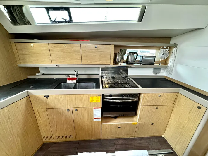  Yacht Photos Pics Modern kitchen in 2018 Beneteau Oceanis 45 yacht with wood cabinetry and appliances.