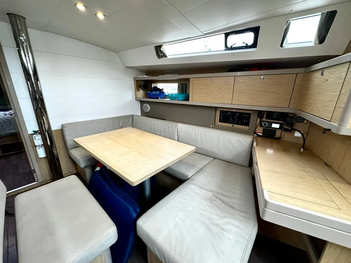  Yacht Photos Pics 2018 Beneteau Oceanis 45 interior with modern seating, wooden table, and compact kitchen area.