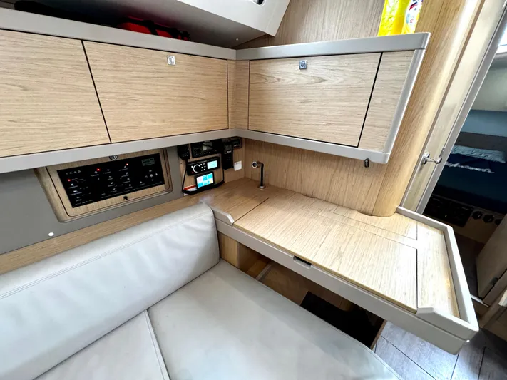  Yacht Photos Pics Interior of 2018 Beneteau Oceanis 45 yacht with wooden cabinetry and seating area.