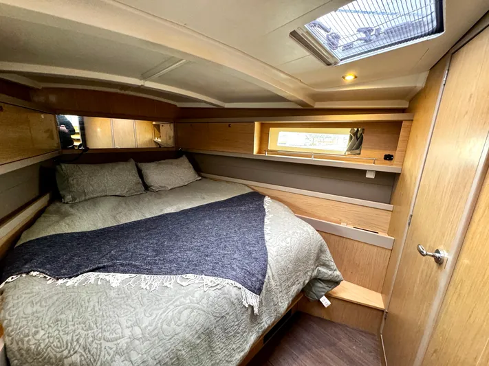  Yacht Photos Pics Cozy cabin interior of 2018 Beneteau Oceanis 45 yacht with double bed and wooden finish.