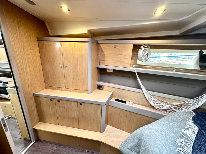  Yacht Photos Pics Interior of 2018 Beneteau Oceanis 45 yacht, featuring wooden cabinetry and cozy sleeping area.