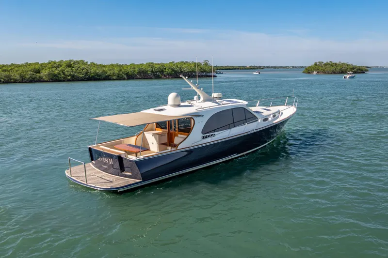Eleven11 Yacht Photos Pics 2018 Palm Beach Motor Yachts PB55 cruising on serene waters, surrounded by lush greenery.