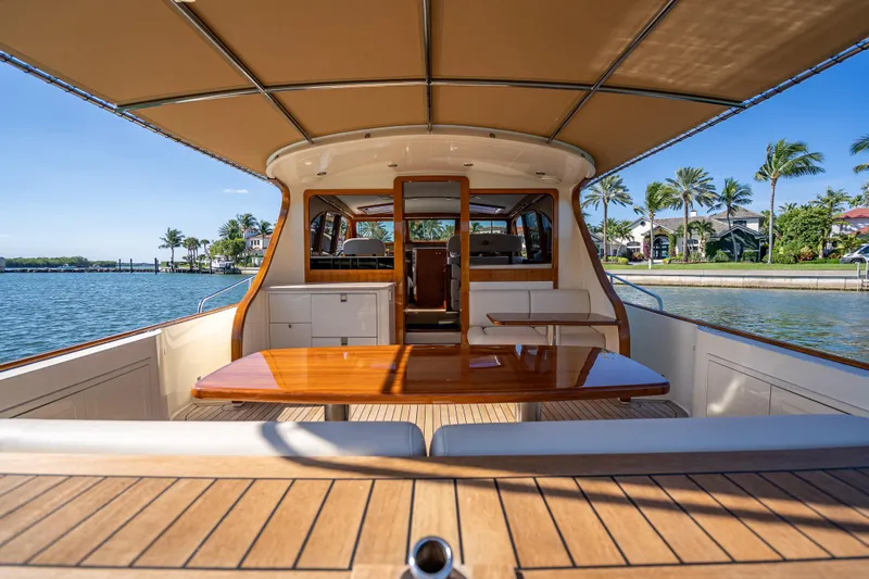 Eleven11 Yacht Photos Pics 2018 Palm Beach Motor Yachts PB55, elegant interior with wooden table, scenic waterfront view.