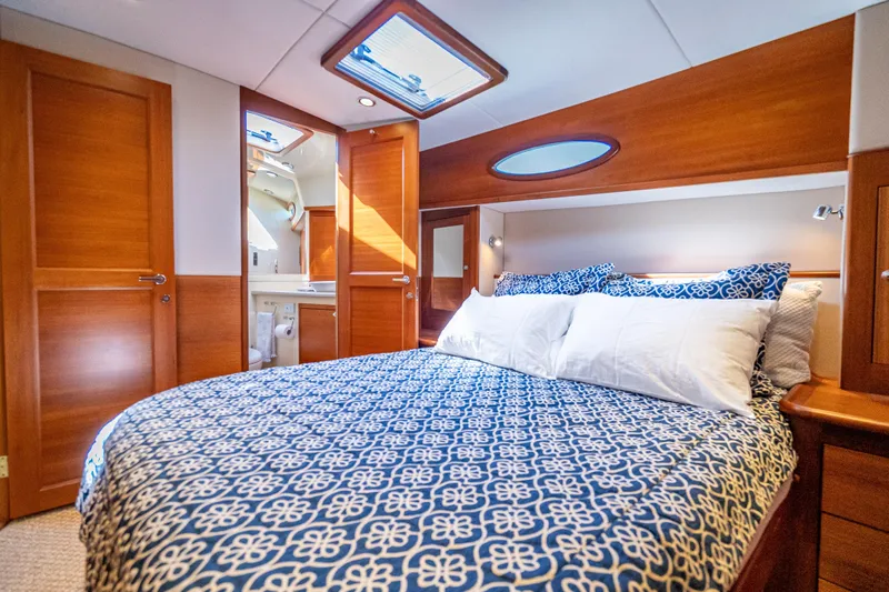 Eleven11 Yacht Photos Pics Luxurious cabin interior of 2018 Palm Beach Motor Yachts PB55 with elegant bedding and wood finishes.