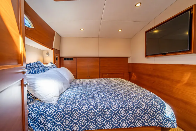 Eleven11 Yacht Photos Pics Luxurious cabin interior of 2018 Palm Beach Motor Yachts PB55 with elegant bedding and TV.
