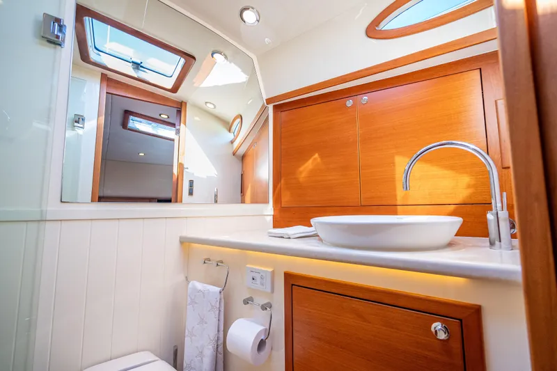 Eleven11 Yacht Photos Pics Luxurious bathroom in 2018 Palm Beach Motor Yachts PB55, featuring elegant wood cabinetry.