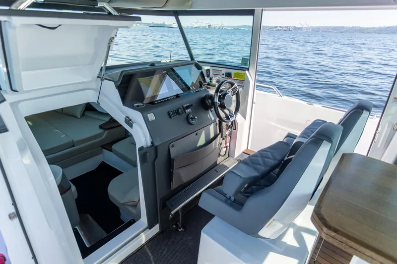  Yacht Photos Pics 2021 Axopar 37XC Aft Cabin interior with helm, seating, and ocean view.