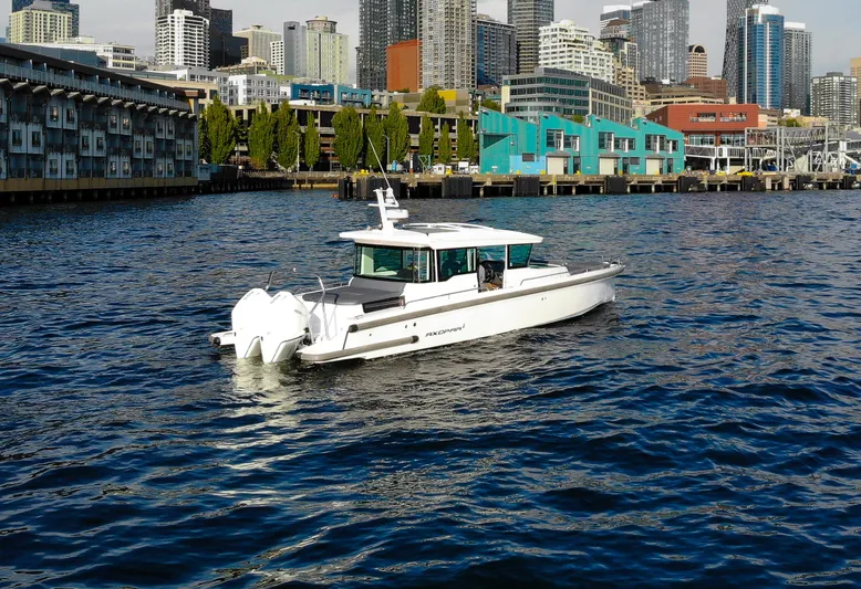  Yacht Photos Pics 2021 Axopar 37XC Aft Cabin boat cruising near urban waterfront skyline.