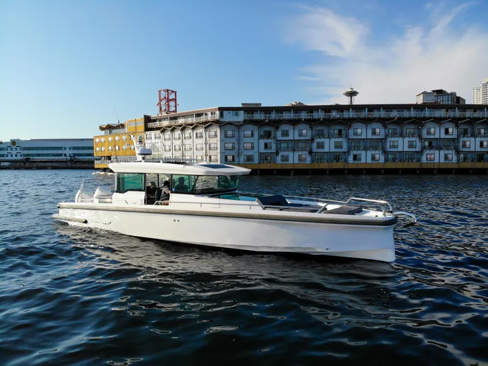 Yacht Photos Pics 2021 Axopar 37XC Aft Cabin boat on water near urban waterfront.