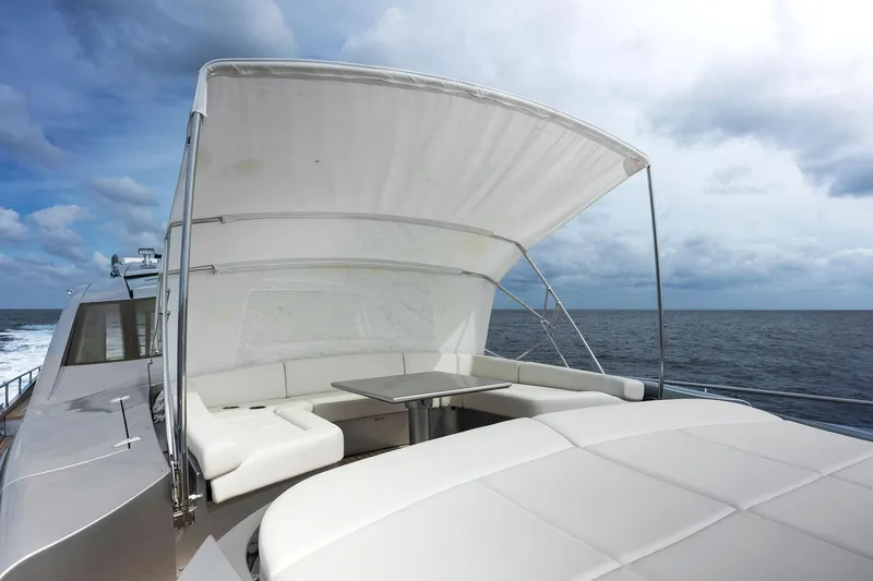 Phoenix Rising Yacht Photos Pics Luxurious 2017 Pershing 82 VHP yacht with shaded seating area on open sea.