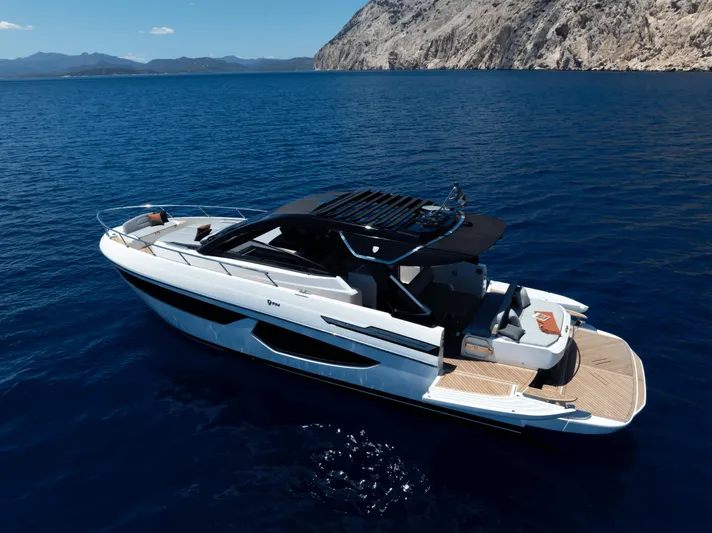  Yacht Photos Pics 2024 FIM 440 Regina yacht cruising in clear blue waters near rocky coastline.