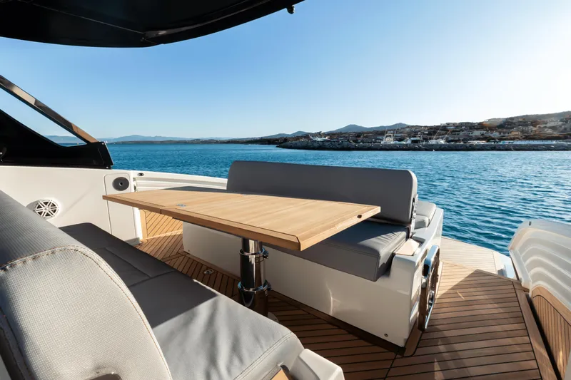 Yacht Photos Pics Luxury deck of 2024 FIM 440 Regina yacht with seating and table, overlooking serene waters.