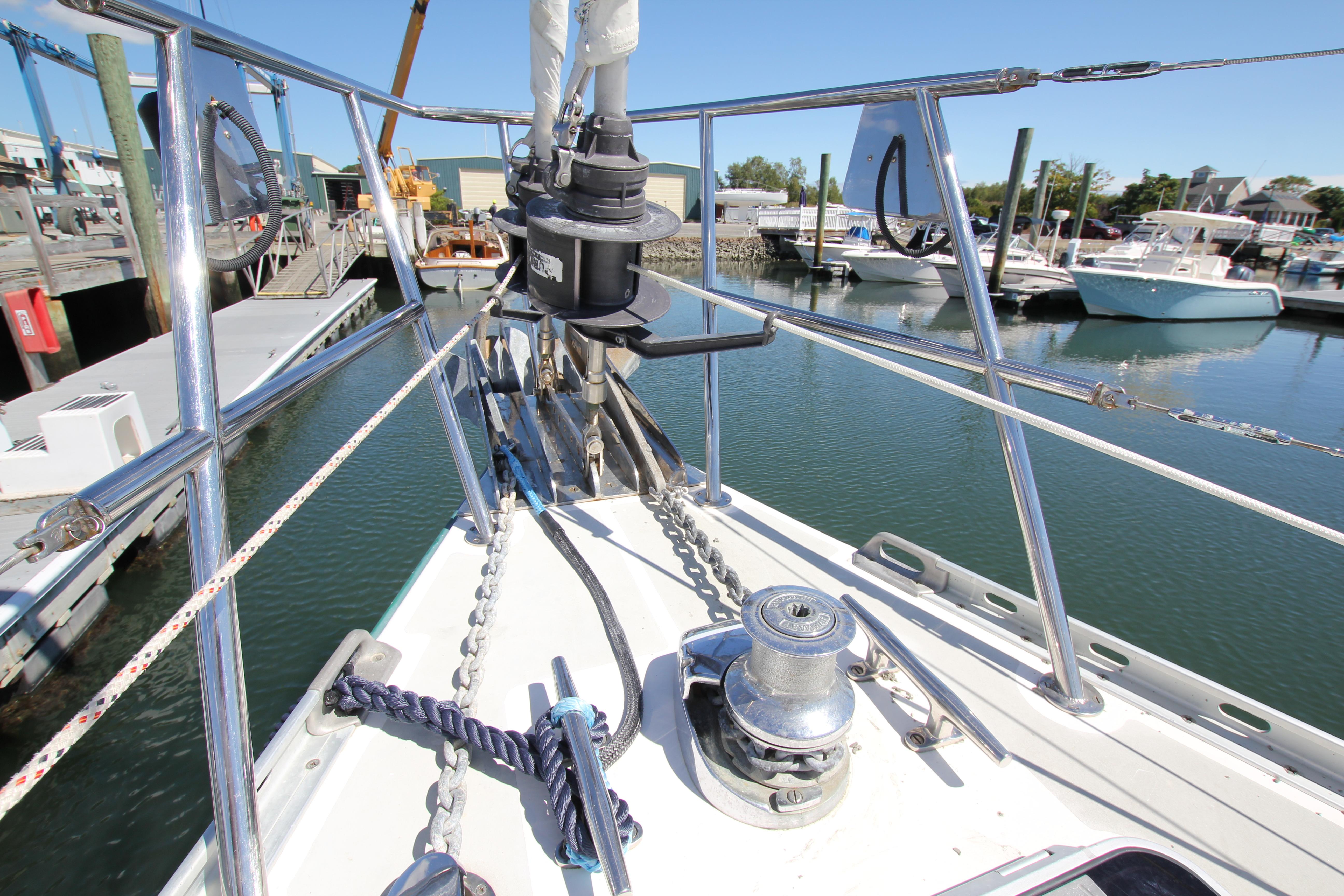 Bow of Able Apogee 50 sailboat, 1998 model, docked in marina with clear blue sky.