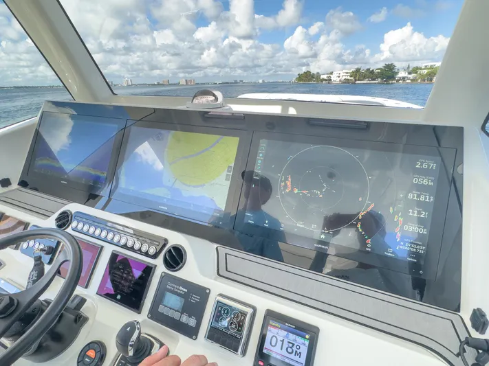 A Salt Weapon Yacht Photos Pics 2022 SeaVee 450z helm with advanced navigation displays and controls on open water.
