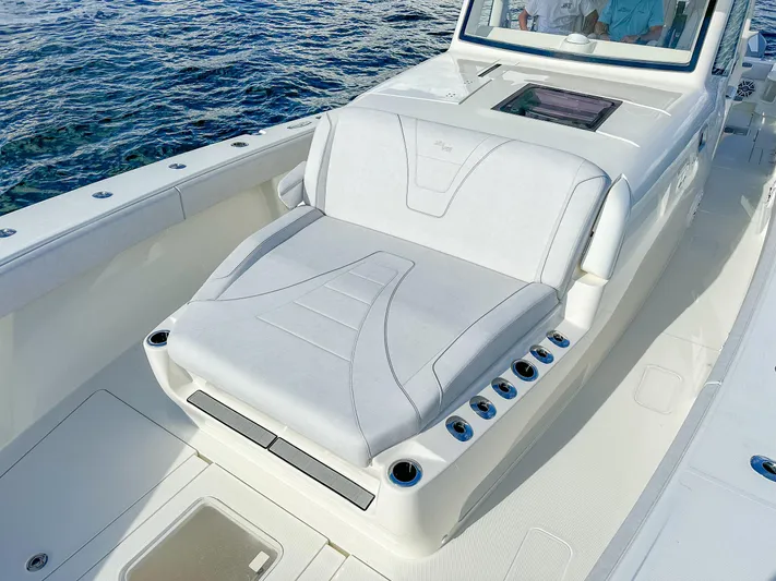 A Salt Weapon Yacht Photos Pics 2022 SeaVee 450z boat with white cushioned seating and cup holders on deck.