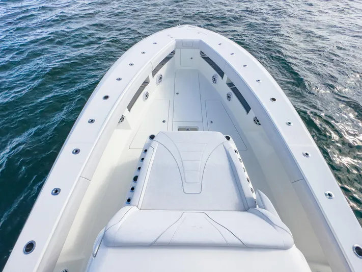 A Salt Weapon Yacht Photos Pics 2022 SeaVee 450z boat bow on water, showcasing sleek design and spacious deck.