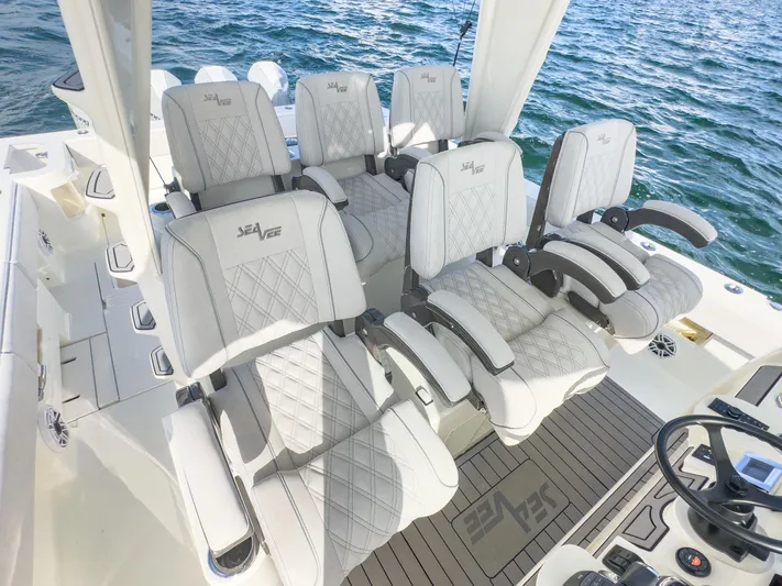 A Salt Weapon Yacht Photos Pics Luxurious seating on 2022 SeaVee 450z boat, featuring elegant white upholstery and ocean backdrop.