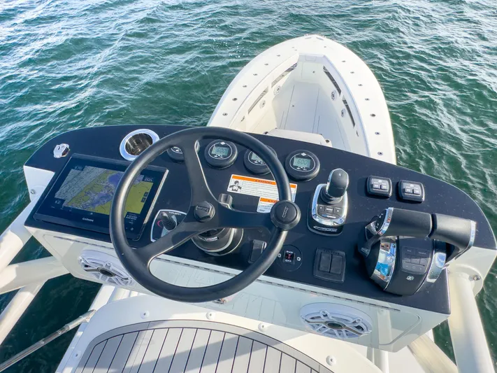 A Salt Weapon Yacht Photos Pics 2022 SeaVee 450z boat helm with navigation controls and steering wheel on open water.
