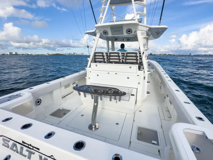 A Salt Weapon Yacht Photos Pics 2022 SeaVee 450z boat on open water, featuring spacious deck and fishing setup.