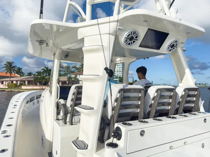 A Salt Weapon Yacht Photos Pics 2022 SeaVee 450z boat with modern seating and electronics, cruising near waterfront homes.