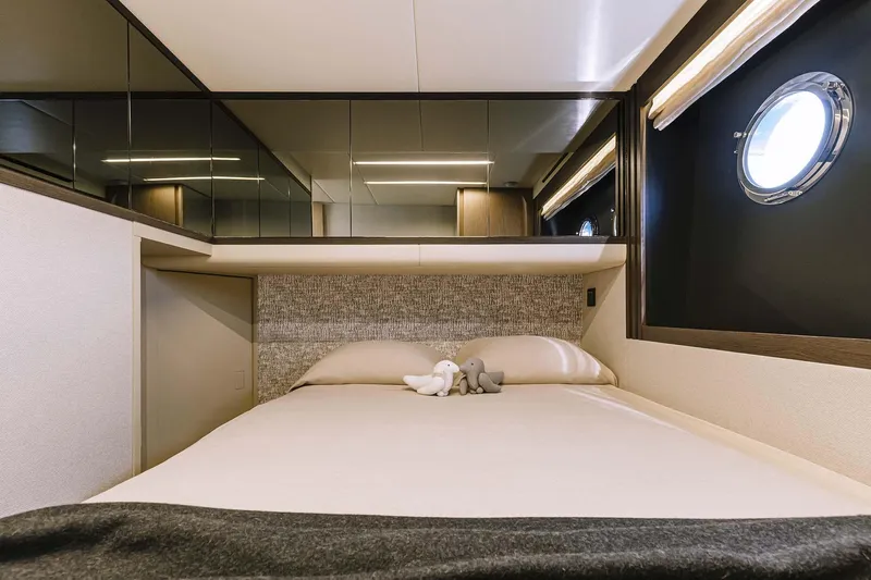  Yacht Photos Pics Luxurious bedroom interior of 2025 Absolute 52 FLY yacht with modern design and porthole window.