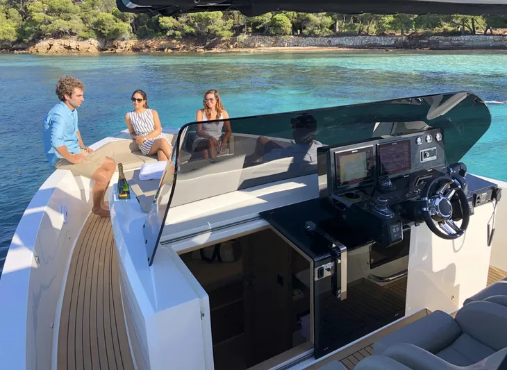  Yacht Photos Pics 2026 De Antonio Yachts D42 with people relaxing on deck in a scenic coastal setting.