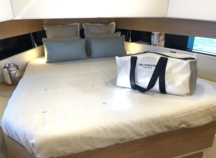  Yacht Photos Pics Luxurious interior of 2026 De Antonio Yachts D42 with elegant bedding and branded bag.