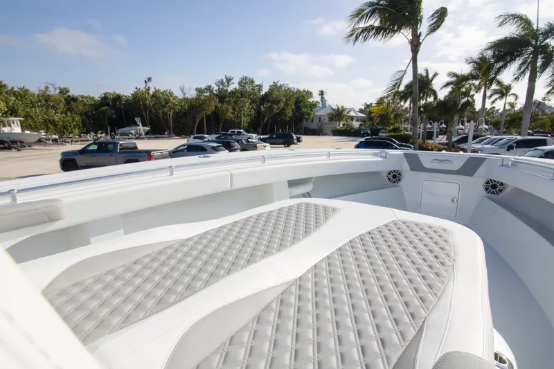  Yacht Photos Pics 2026 Invincible 39 Open Fisherman boat with cushioned seating, parked near palm trees.