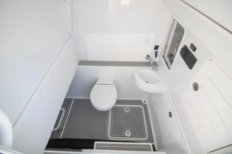  Yacht Photos Pics Interior of 2026 Invincible 39 Open Fisherman boat bathroom, featuring toilet and sink.