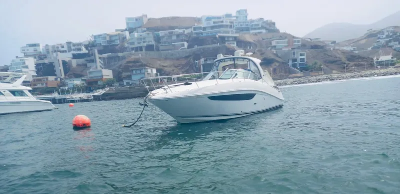 Knot On Call Yacht Photos Pics 2013 Sea Ray Sundancer 370 yacht anchored near coastal hillside homes.