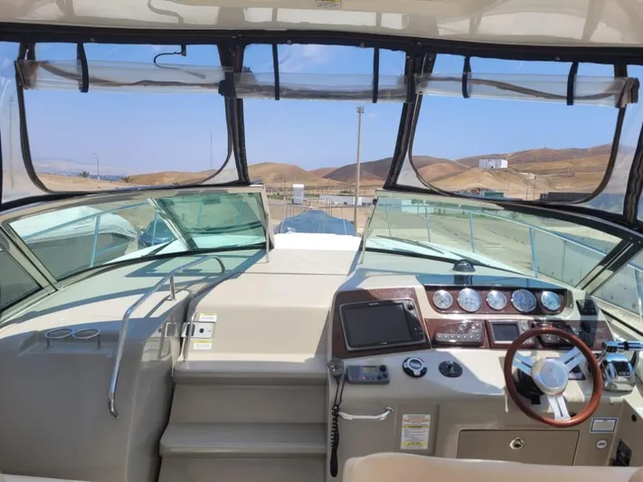 Knot On Call Yacht Photos Pics Helm of 2013 Sea Ray Sundancer 370 with dashboard and steering wheel, overlooking marina.